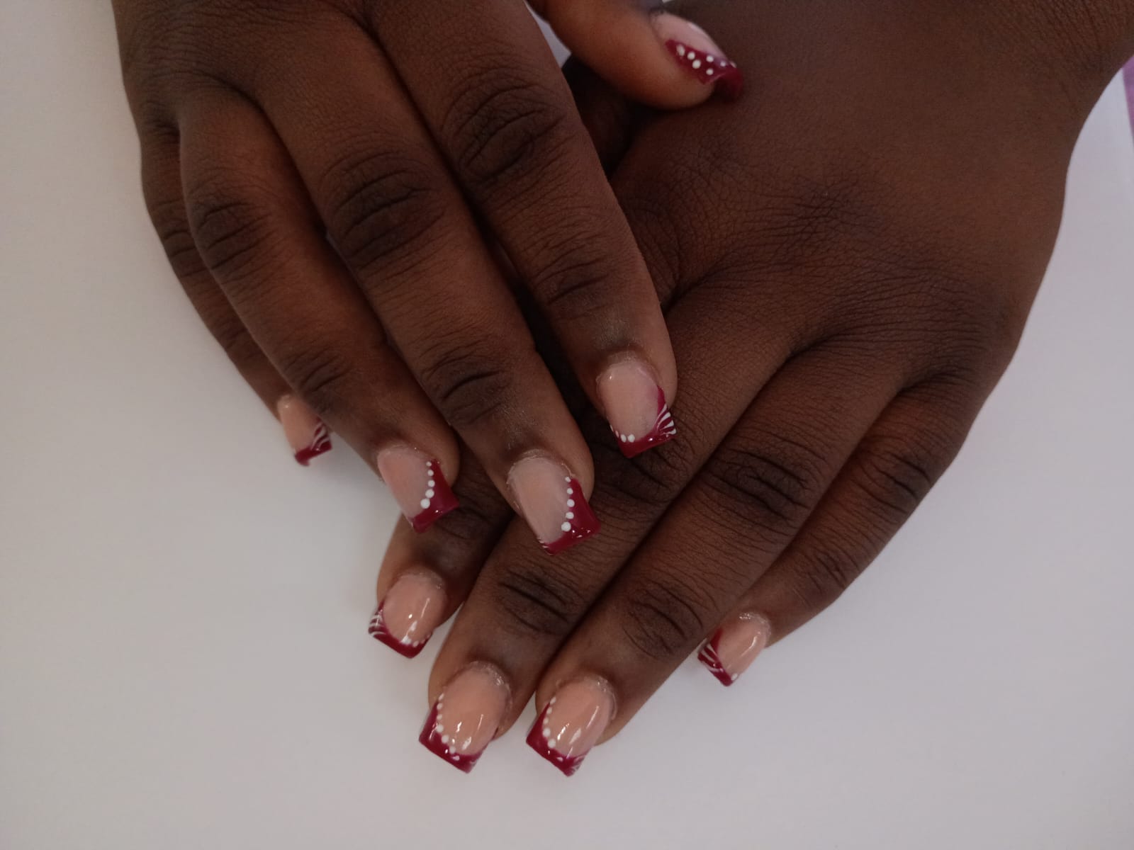 Burgundy French tips with white dot and fan accents.